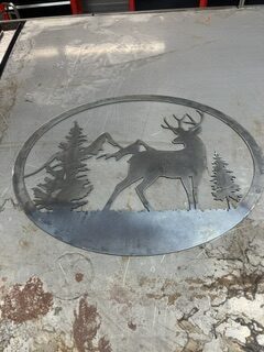 Custom plasma-cut metal sign featuring a deer, mountains, and evergreen trees